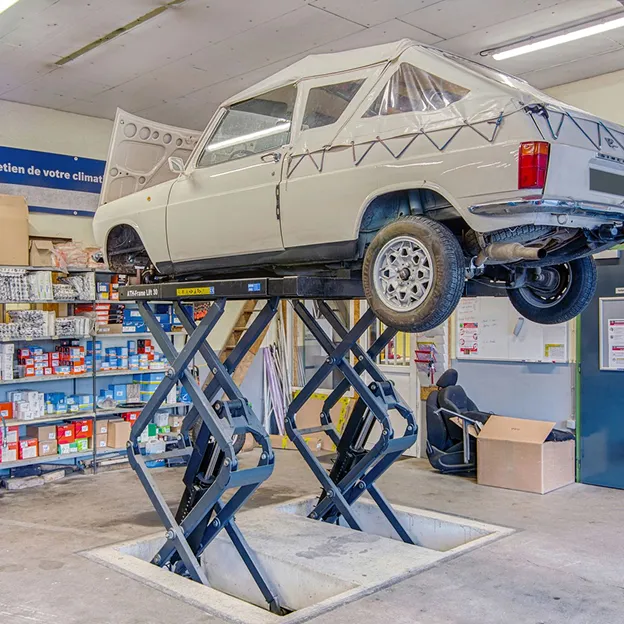 Voiture blanche sur un pont élévateur à ciseaux dans un garage à Azay-sur-Thouet dans les Deux-Sèvres 79