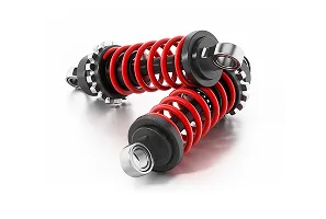 Deux amortisseurs de voiture, rouges et noirs, posés en forme de V.