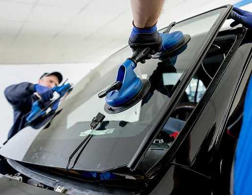 Techniciens remplaçant un pare-brise de voiture à l'aide de ventouses à Azay-sur-Thouet dans les Deux-Sèvres 79